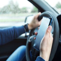 Man in car is using smartphone. Concepts of ridesharing, driving safety or GPS navigation.